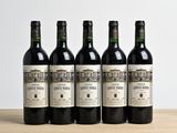 four bottles of wine are lined up on a wooden table