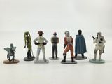 the figurines of star wars characters are lined up on a white surface