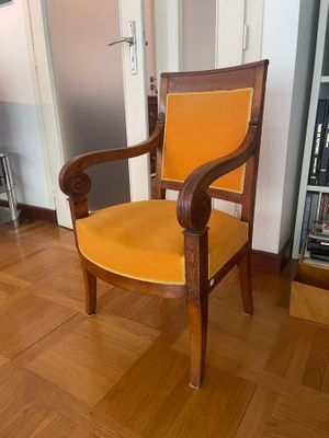 a wooden chair with a yellow seat in a room