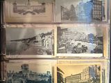 many pictures of old buildings on display in a glass case