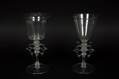 two clear glass goblets sitting next to each other on a black surface
