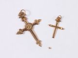 two gold crosses and a cross on a white surface