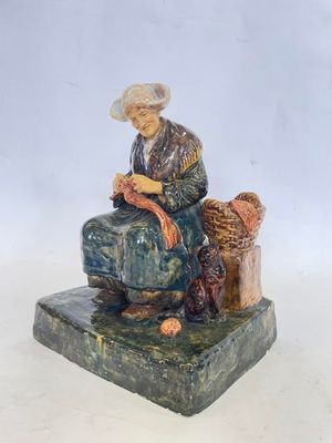 figurine of a woman sitting on a rock with a dog