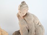 a statue of a man sitting on a rock next to a dog