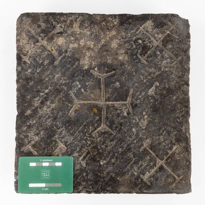 a close up of a piece of stone with a cross on it