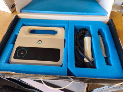 une boîte bleue contenant un appareil électronique blanc