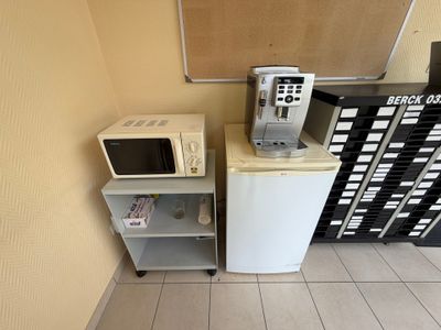 deux micro-ondes et un réfrigérateur dans une petite pièce