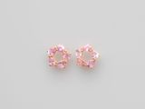 une paire de boucles d'oreilles en cristal rose sur fond blanc