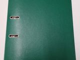 a green binder sitting on top of a table next to a pair of scissors
