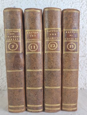 a set of four old books sitting on top of a table