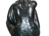 statue of a woman sitting on a base with her back to the camera