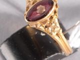 une image représentant une bague en or sertie d'une grenat