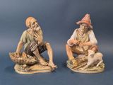 deux figurines d'un homme et d'une femme assis sur un rocher