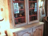 a white china cabinet with glass doors in a room
