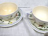 two cups and saucers sitting on a table