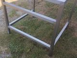 a close up of a metal frame in the grass near a car