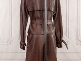 brown leather trench coat on a mannequin stand in front of a white wall