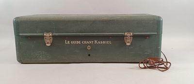 une valise verte posée sur une surface blanche