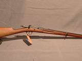 un vieux fusil avec un canon en bois sur un support sur fond blanc