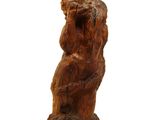 une statue en bois représentant un ours assis sur une souche d'arbre