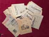 Plusieurs vieux journaux sont éparpillés sur une surface rouge