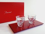 two glasses on a tray with a red box in the background