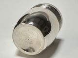 a silver shaker sitting on top of a white table