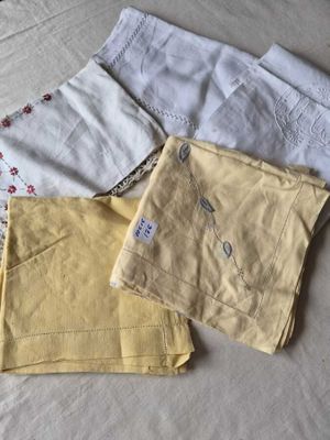 trois paires de pantalons jaunes posées les unes à côté des autres sur un lit