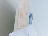 a hand holding a piece of paper with a note attached to it