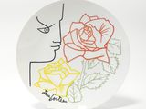 une assiette sur laquelle est représentée une femme et une rose