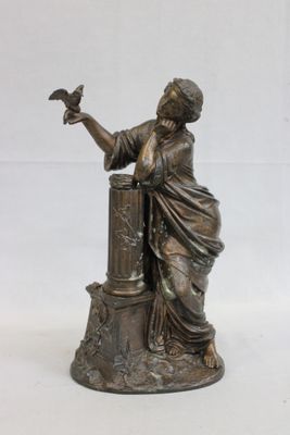 une statue représentant une femme tenant un oiseau sur la main