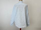 a white shirt with black stars on it sitting on a mannequin