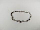 a close up of a silver chain bracelet on a white surface