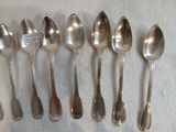 six cuillères en argent sont alignées sur une table