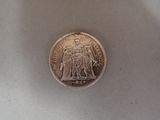 a silver coin with a picture of a man and a woman on it