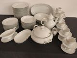 beaucoup d'assiettes et de tasses blanches sur une table