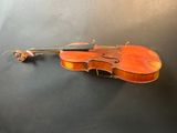 an old violin sitting on top of a table next to a flower