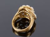 a close up of a gold and diamond ring on a black surface