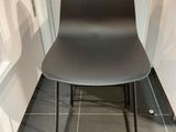 une chaise noire placée dans une cuisine, à côté d'un plan de travail