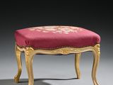 a gold and red upholstered stool with a red cushion