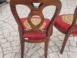 two wooden chairs with red cushions on them on a patio