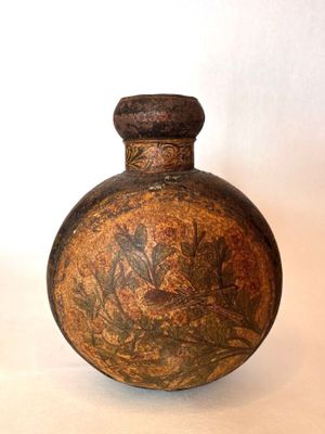 un petit vase marron orné d'un motif floral