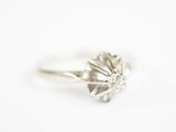 une image d'une bague en diamant sur une surface blanche