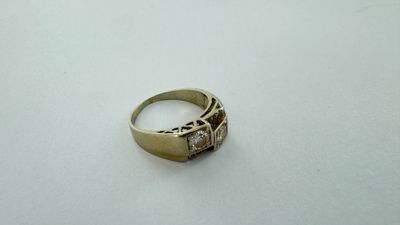 gros plan d'une bague en or sur une surface blanche