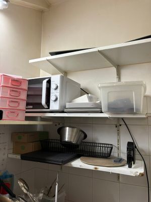 a microwave sitting on top of a shelf in a kitchen