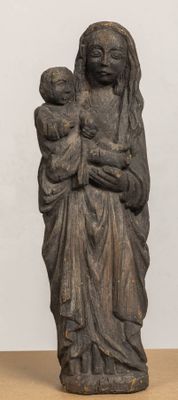 an old statue of a woman holding a child on a table