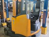 a forklift in a warehouse with other equipment in the background
