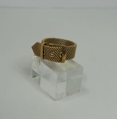 a close up of a gold ring on a clear glass block