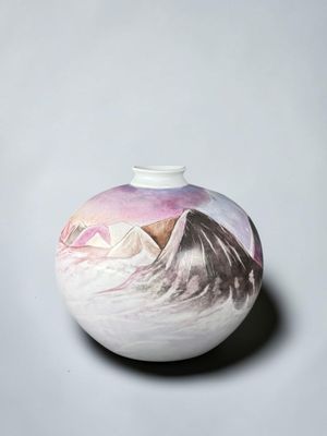a white vase with a picture of a mountain on it