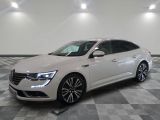 la voiture blanche est garée sur un sol en damier dans le garage